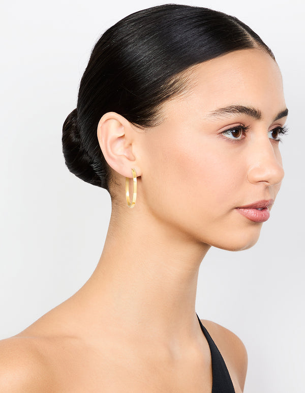 Stylish waterproof medium flat hoop earrings in gold plated stainless steel on model view