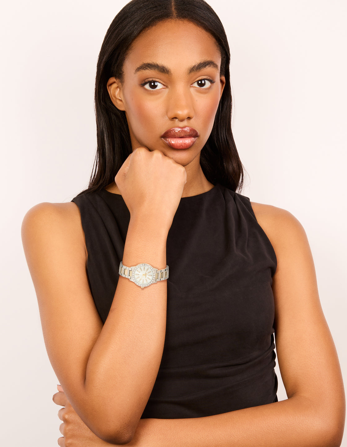 Stylish women's watch clear stone dial, round shape, formal aesthetic, multi-color link band strap, and gold analog timepiece on model view