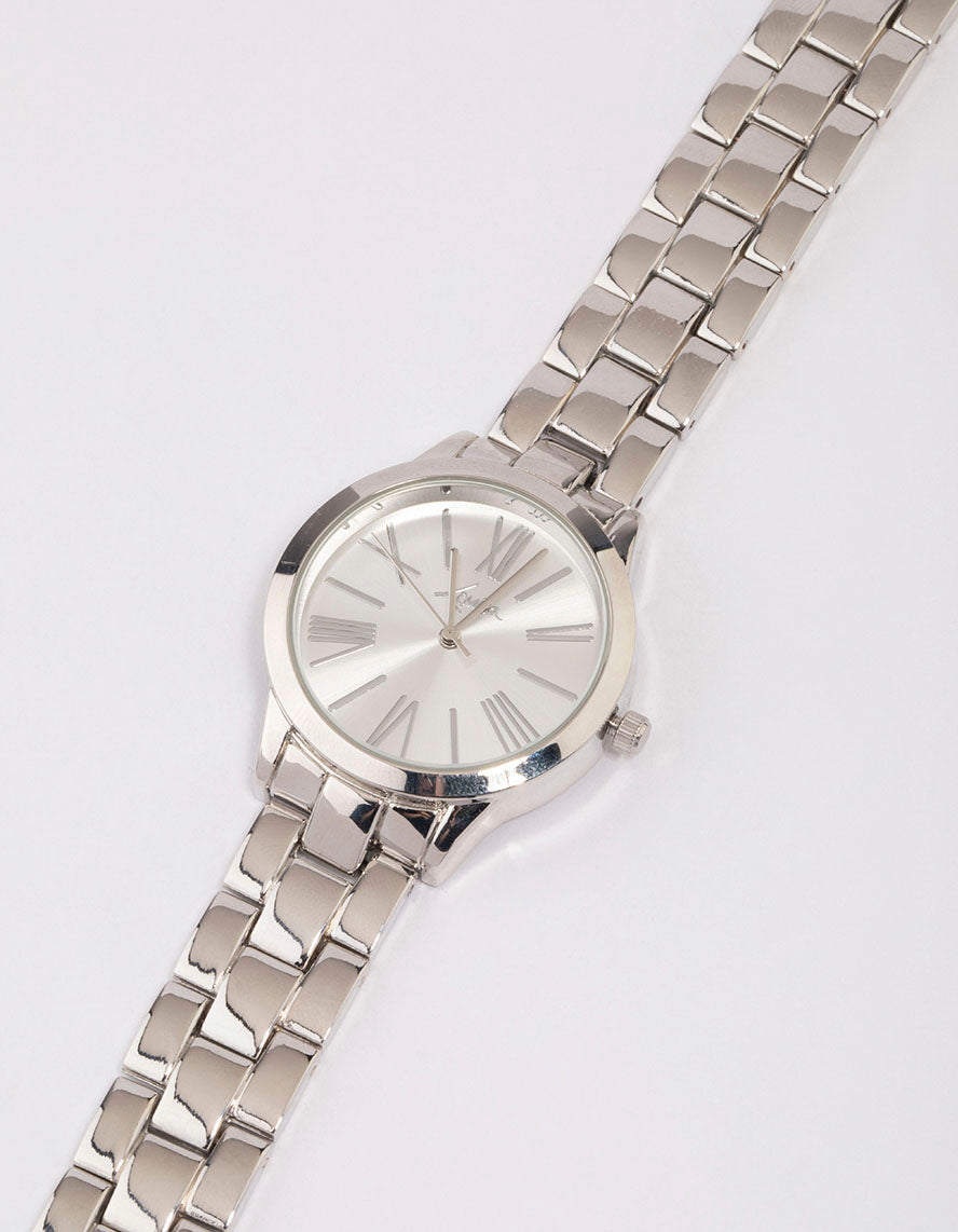 Showcasing a large roman numeral watch with white dial, round shape, and link band strap in silver, designed for women's formal occasions with analog type watch face detail view
