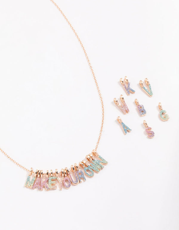 Discover this kids gold DIY rainbow charm necklace kit featuring glitter initials in pink aqua and lavender close up view