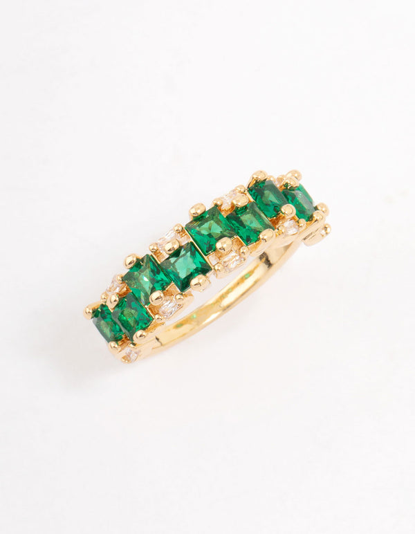 Elegant gold plated staggered band ring with emerald cut cubic zirconia in dark green side detail view