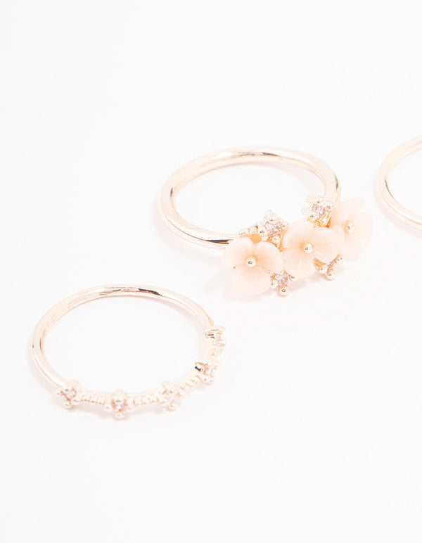 Featuring rose gold plated triple flower stacking ring pack in dainty style close up view
