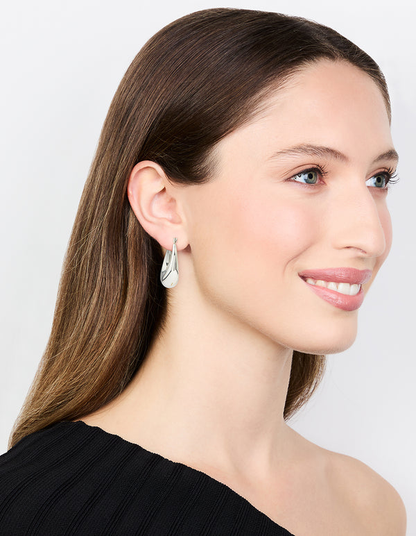 Featuring waterproof stainless steel full loop drop hoop earrings in silver on model view