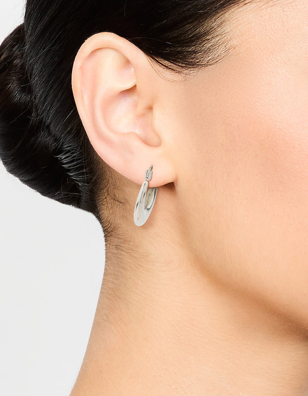 Featuring waterproof flat crescent hoop earrings crafted from stainless steel in silver on ear view