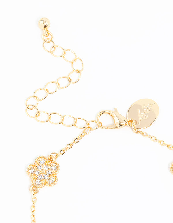 Highlighting the gold plated alternating small and medium flower bracelet with charm elements in white closure detail view