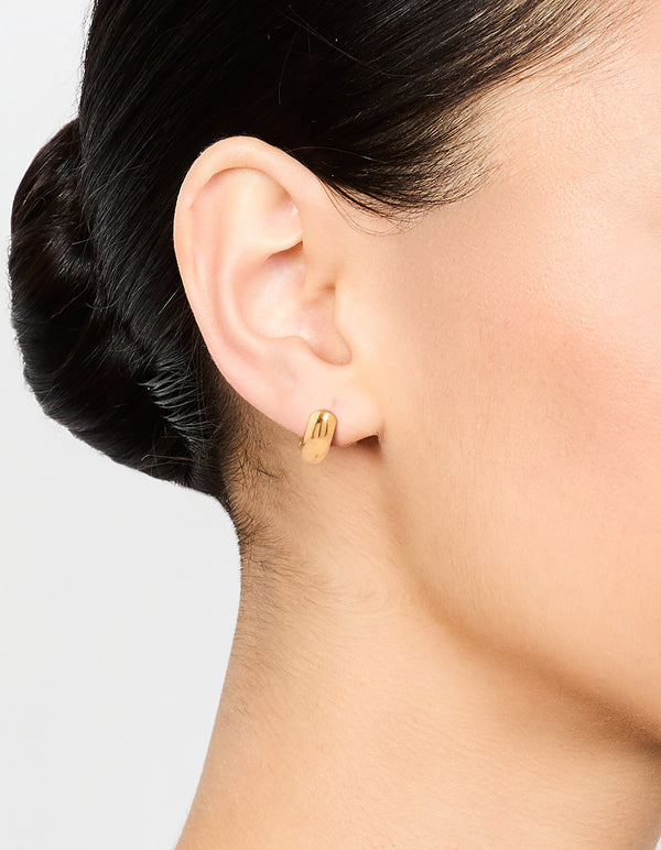 Showcasing waterproof gold plated stainless steel chubby huggie earrings with closure on ear view