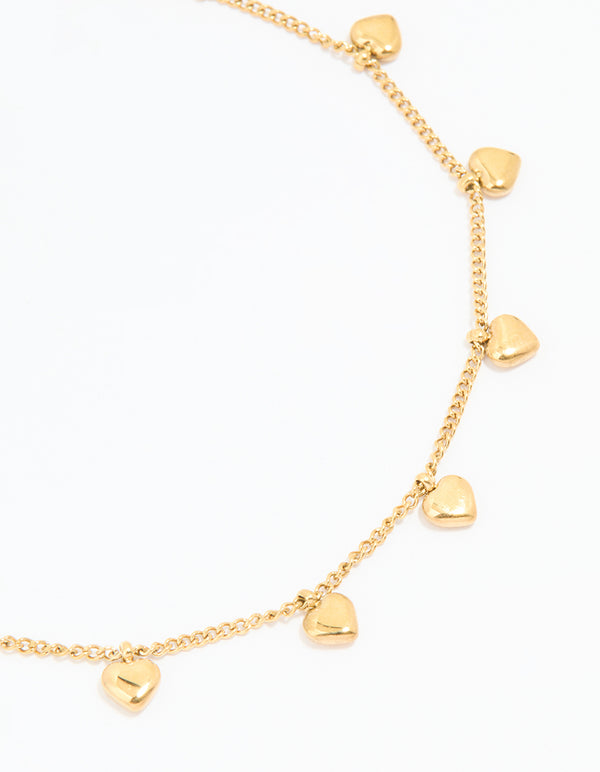 Showcasing waterproof gold plated stainless steel dainty anklet with heart charms and ball accents in gold side view