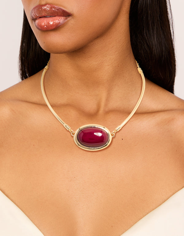 Featuring a gold red large stone and tube necklace in crimson on neck view