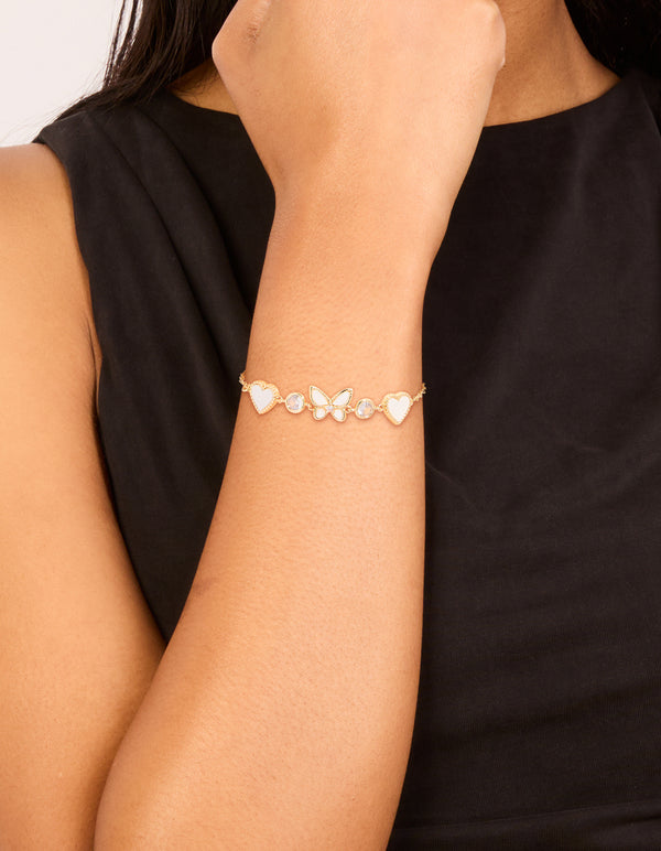 Showcasing a gold plated cubic zirconia butterfly and heart toggle bracelet on wrist view