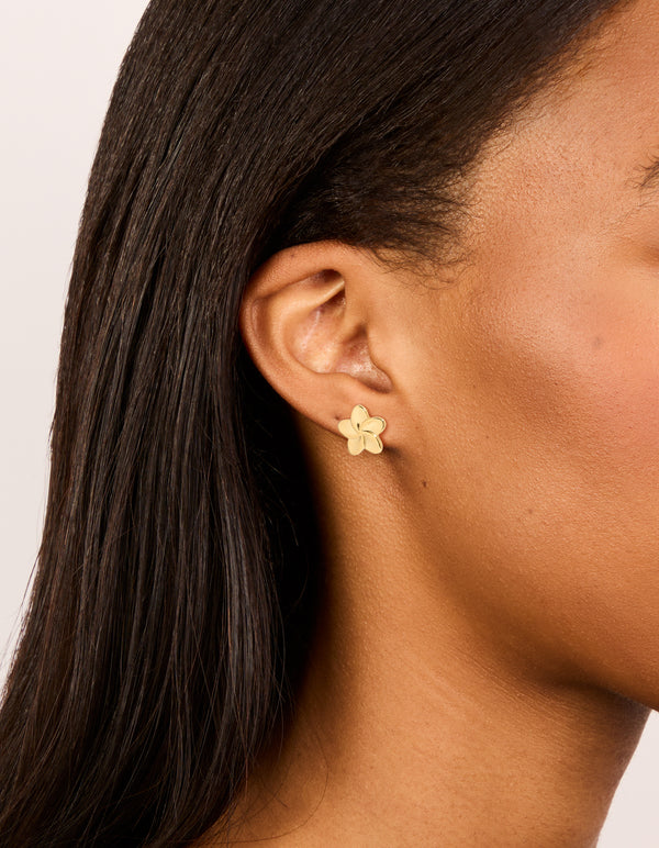 Showcasing waterproof gold plated stainless steel smooth flower stud earrings on ear view