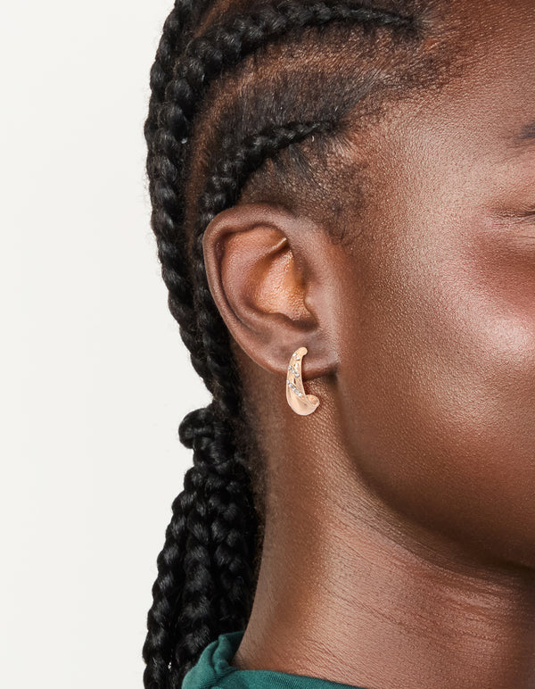 Showcasing gold diamante pear open hoop earrings with white crystal accents on ear view