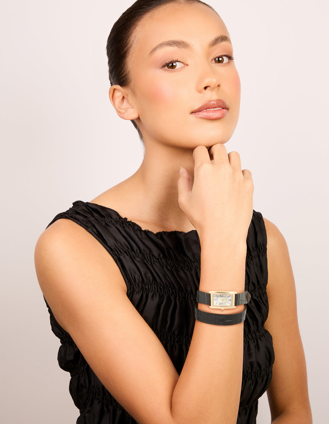 Beautifully crafted, this women's analog watch with white dial featuring roman numerals, rectangular shape, formal styling, black PU leather strap, and gold accents on model view