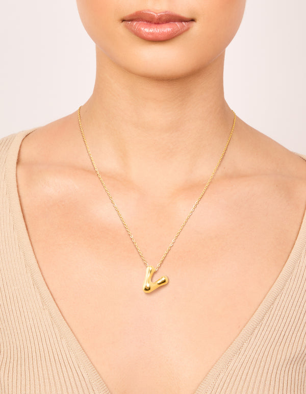 Showcasing a waterproof gold plated stainless steel large bubble letter V initial pendant necklace on neck view