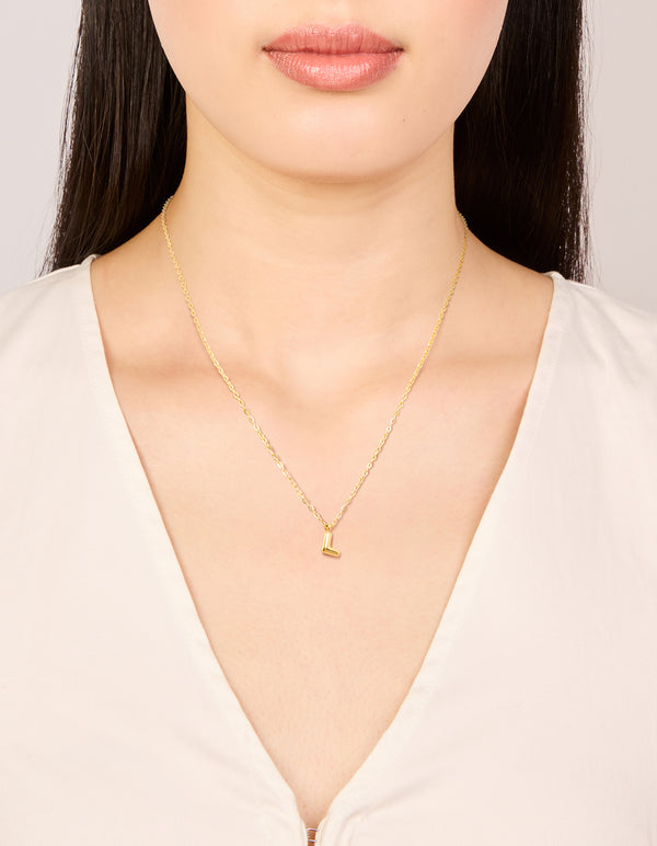 Featuring a waterproof bubble letter L initial pendant necklace, crafted from stainless steel and gold plated in dainty style on neck view