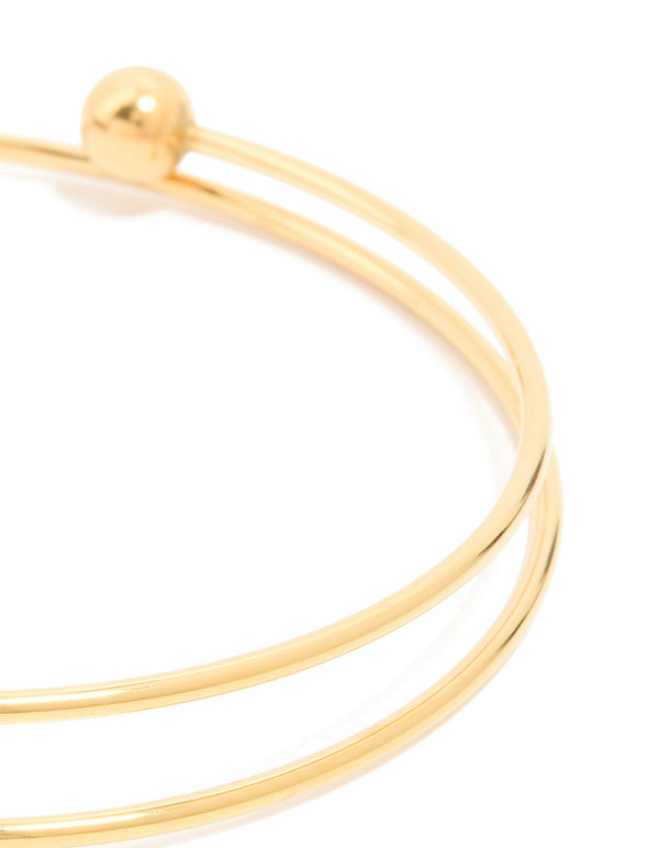 Featuring a waterproof ball end bangle in gold plated stainless steel close up view
