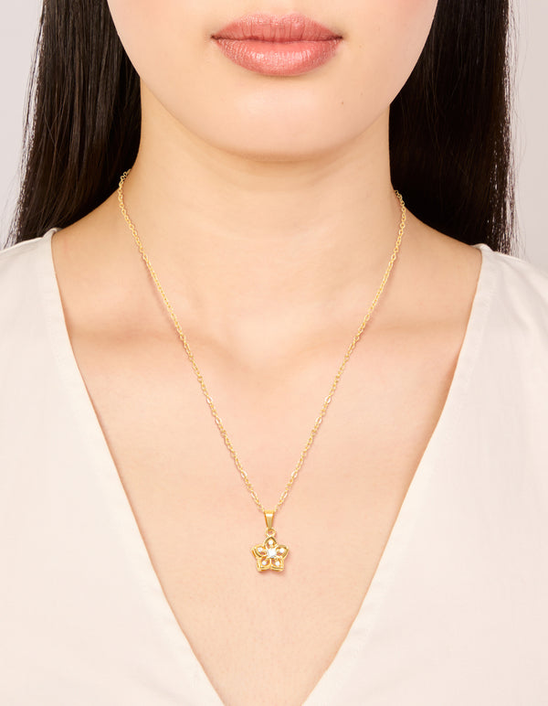 Showcasing a waterproof gold plated stainless steel cubic zirconia flower outline pendant necklace on neck view