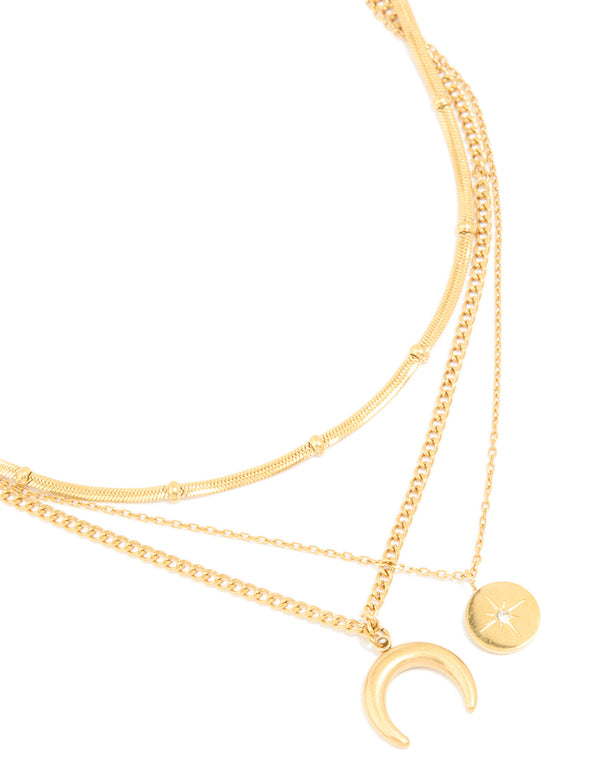 Showcasing a waterproof layered necklace crafted from gold plated stainless steel with celestial charm pendants featuring star, moon and balls close up view