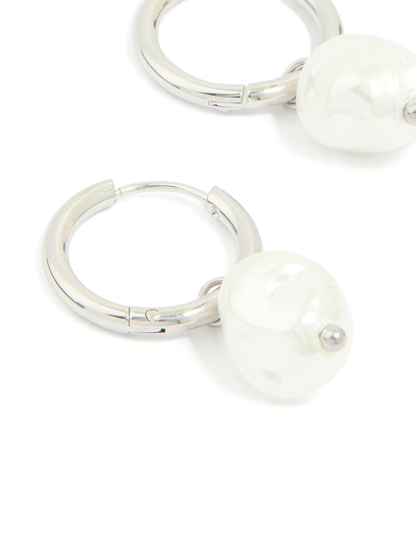 Discover waterproof stainless steel pearl huggie earrings in white and silver close up view