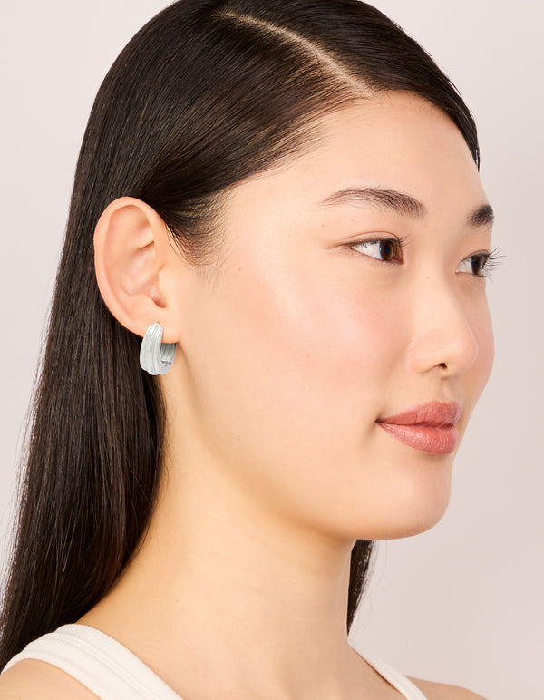 Designed with waterproof stainless steel hinge hoop indented earrings in silver on model view