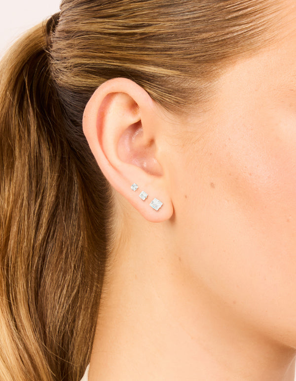 Featuring waterproof stainless steel cubic zirconia square stud earrings in a 3-pack with silver and clear stones on ear view