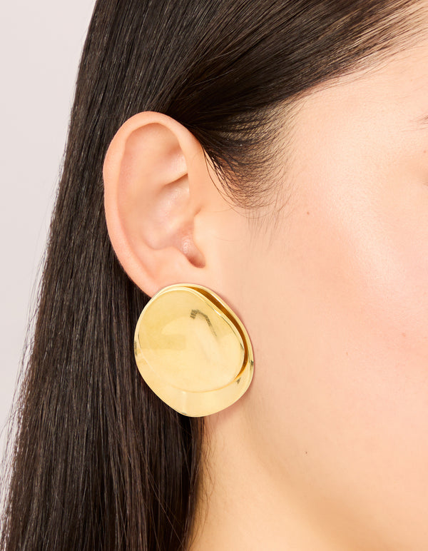 Featuring waterproof double crinkle disc stud earrings in gold plated stainless steel on ear view