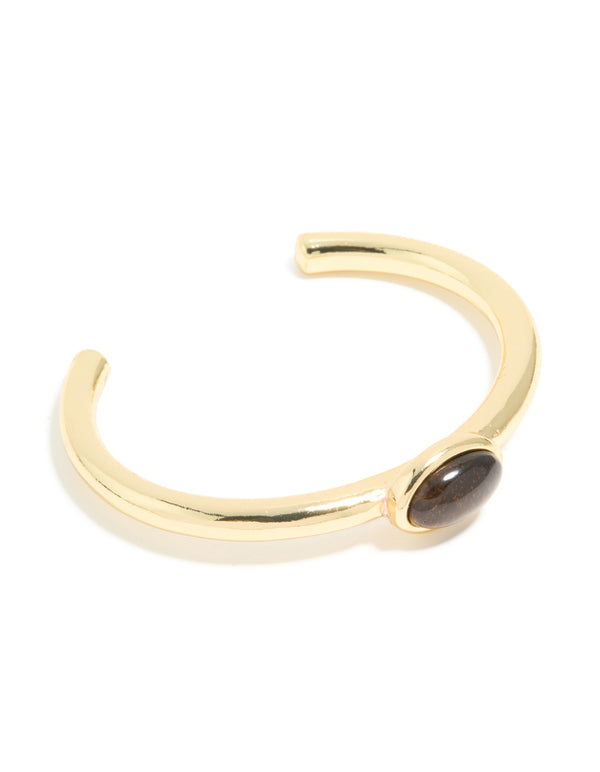 Crafted from waterproof gold plated stainless steel, this open wrist cuff features a tigers eye semi precious stone front view