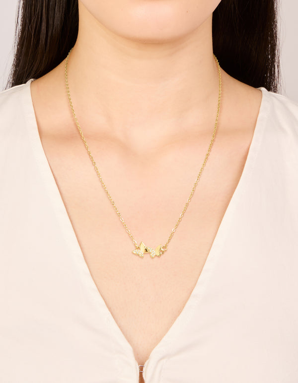 Showcasing a waterproof butterfly pendant necklace crafted from stainless steel in gold plated finish with cubic zirconia and dainty styling on neck view