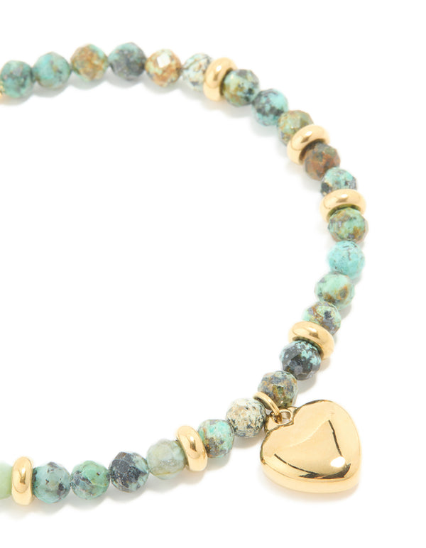 Presenting a waterproof beaded, heart bracelet with turquoise semi precious stone and gold plated stainless steel in dainty style close up view