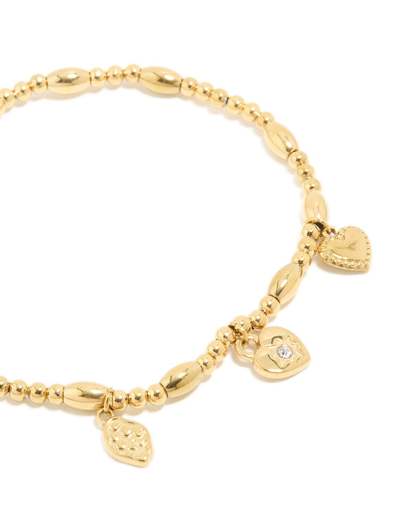 Highlighting the intricate beaded, padlock, and charm details of this waterproof triple heart stretch bracelet, crafted from gold plated stainless steel, in close up view