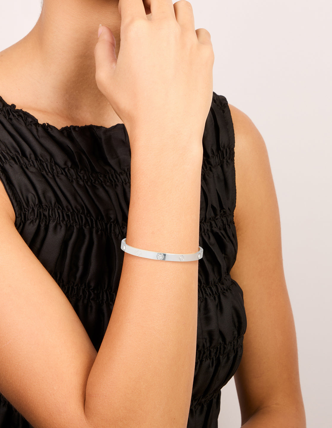 Showcasing a waterproof stainless steel cubic zirconia flower bangle in silver on wrist view