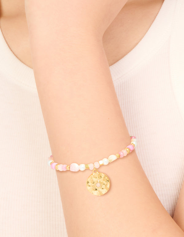 Showcasing a waterproof gold plated stainless steel coin beaded bracelet featuring rose quartz and pearl accents on wrist view