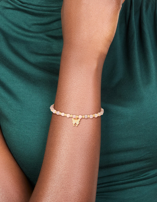 Showcasing a waterproof gold plated stainless steel amethyst semi precious stone butterfly stretch bracelet with beads on wrist view