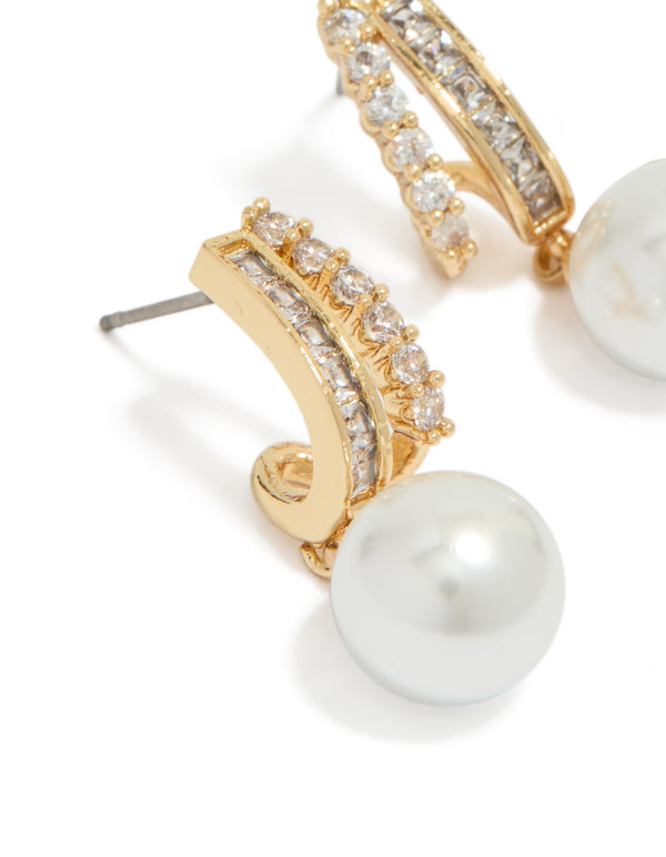 Featuring gold plated cubic zirconia illusion pearl drop earrings with hoop closure in white close up view