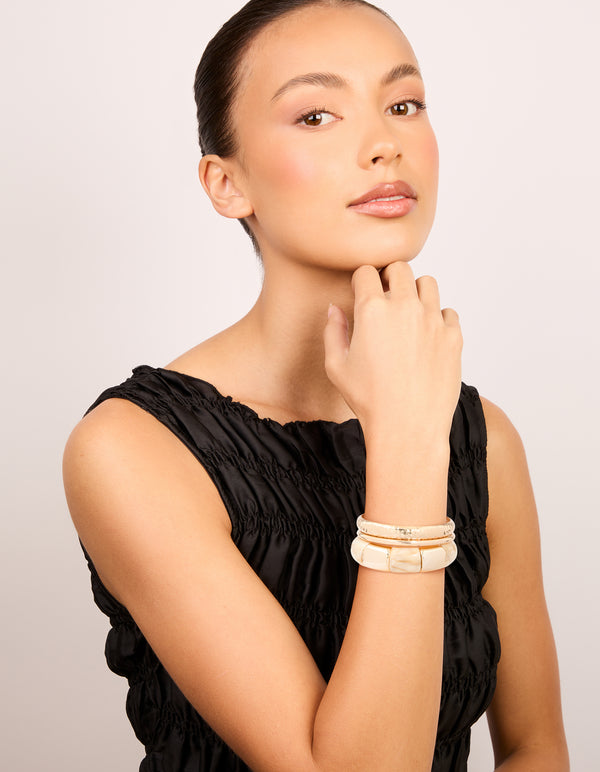 Crafted from cream acrylic with stretch bangle and bangles in a 3-pack on model view