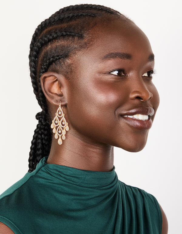 Stunning gold diamante diamond shaped dangly earrings with charm accents on model view