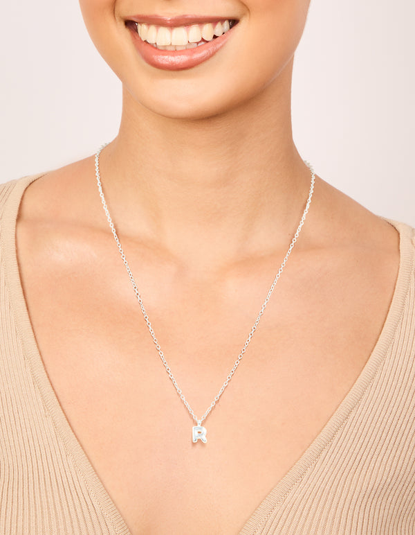 Designed with waterproof stainless steel mini bubble letter R necklace featuring initial and pendant in silver dainty styling on neck view