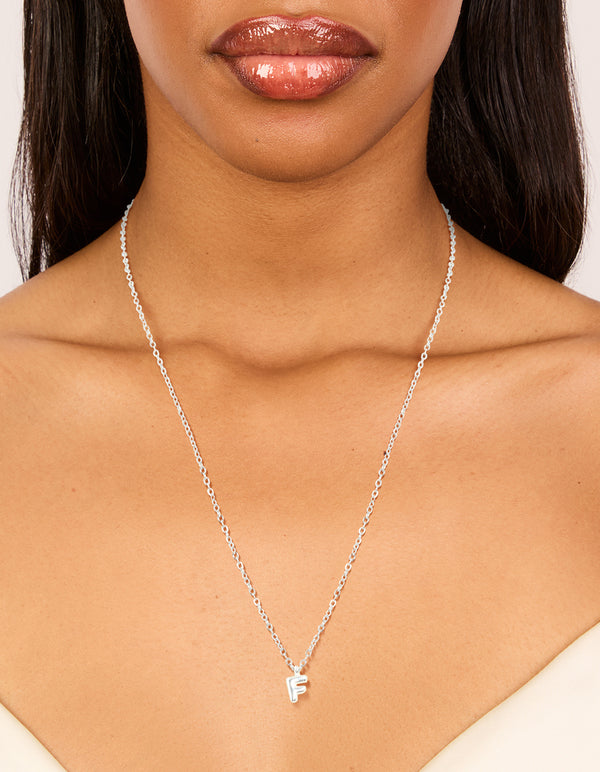 Designed with waterproof stainless steel mini bubble letter F initial pendant necklace in silver on neck view
