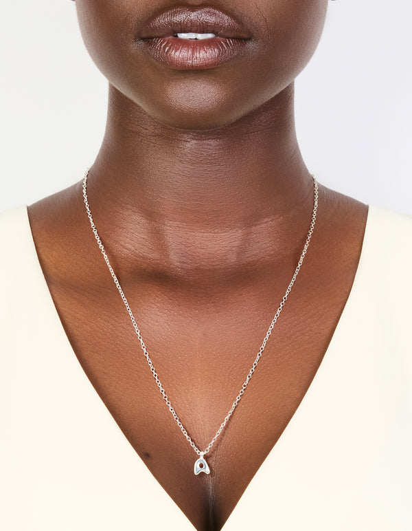 Showcasing a waterproof stainless steel mini bubble letter A necklace with initial pendant in silver on neck view