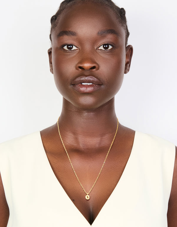 Featuring waterproof gold plated stainless steel with mini bubble letter O initial pendant necklace on model view