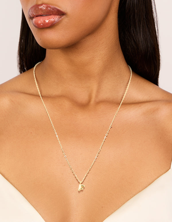 Featuring a waterproof bubble letter F initial pendant necklace crafted from stainless steel with gold plated on neck view