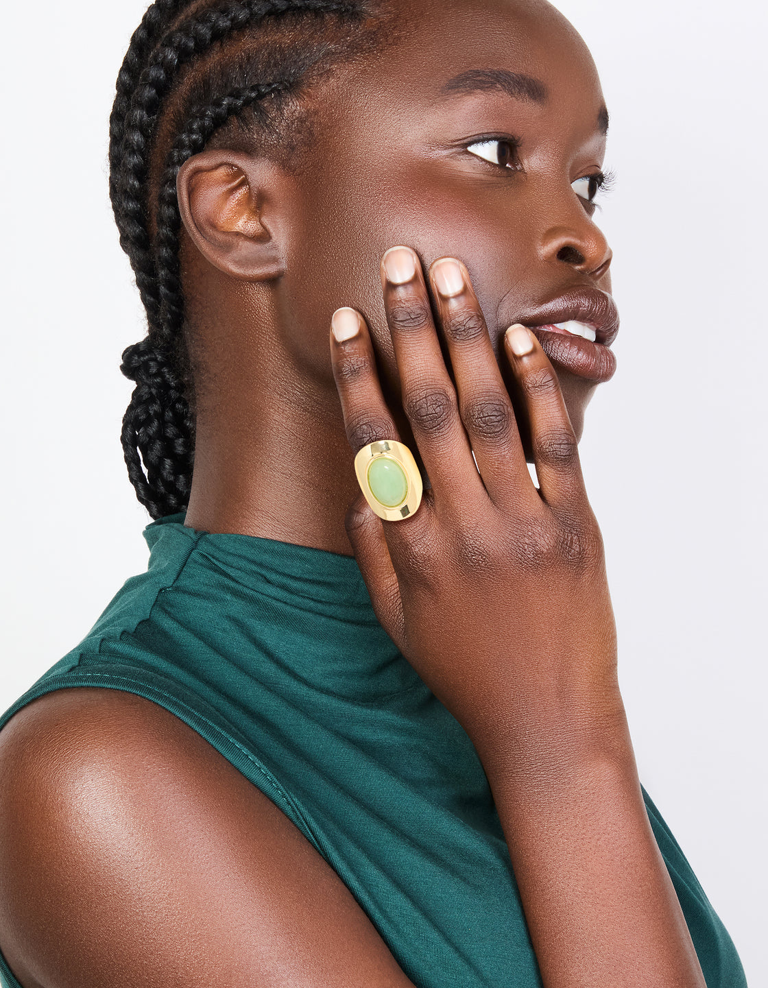 Featuring a gold plated oval green semi precious stone ring on finger view