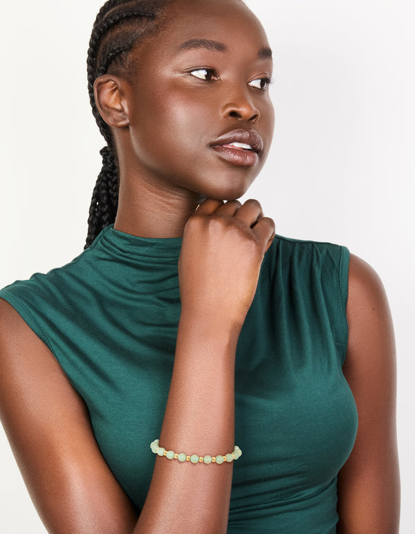Designed with a waterproof beaded stretch bracelet in gold plated stainless steel with pale green beads on model view