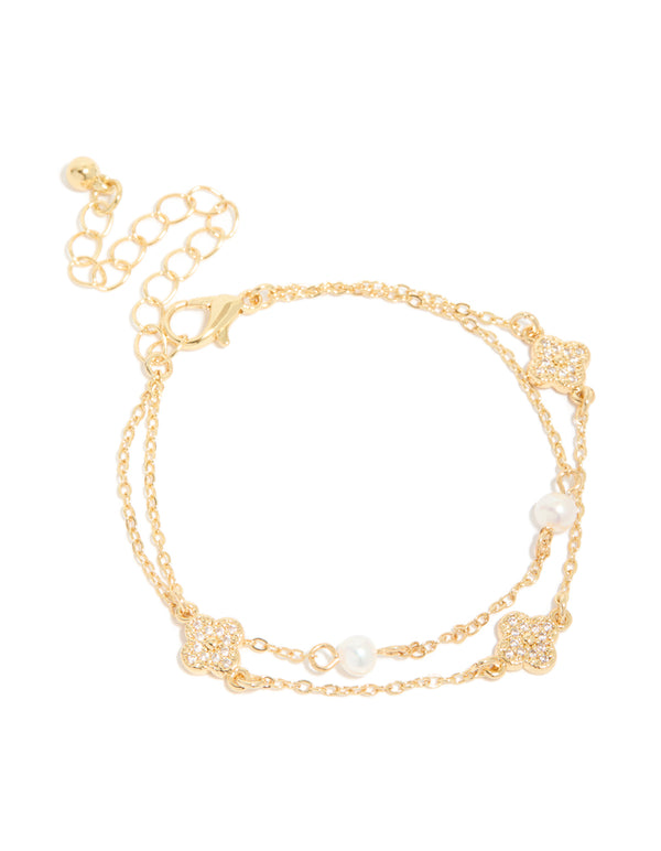 Showcasing a dainty gold plated cubic zirconia flower and freshwater pearl layered bracelet front view