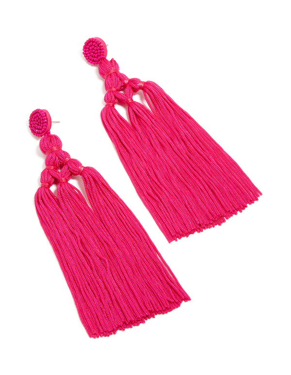 Showcasing statement hot pink fabric tassel drop earrings with beads in a vibrant design front view