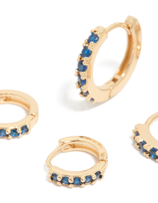 Crafted from gold with sapphire and clear cubic zirconia, these huggie earrings come in a 3-pack close up view