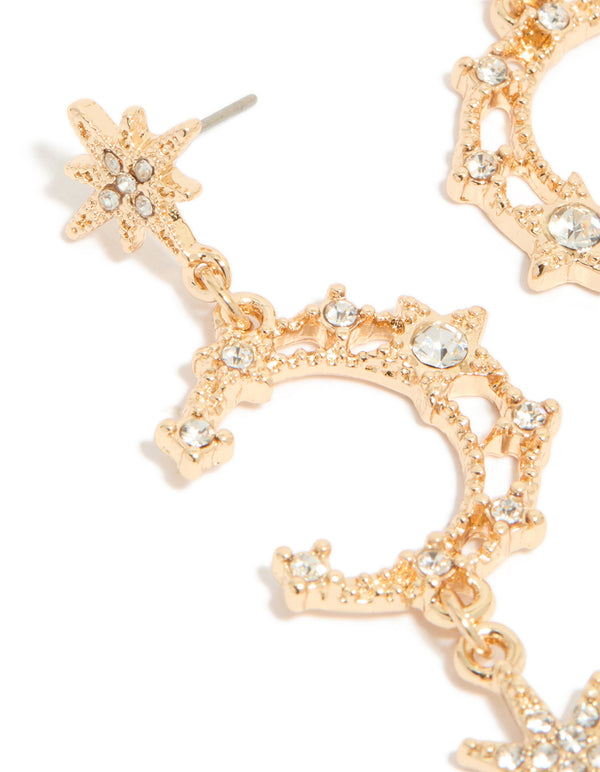 Detailed view of gold diamante moon and star celestial drop earrings in close up view
