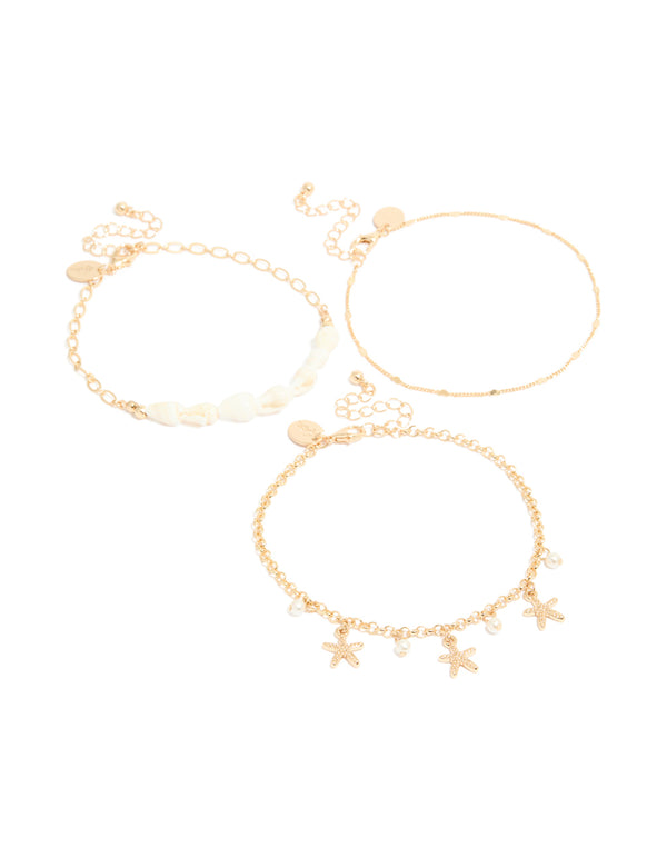 Featuring gold shell and starfish anklets 3-pack with ocean-inspired charm details and pearls front view