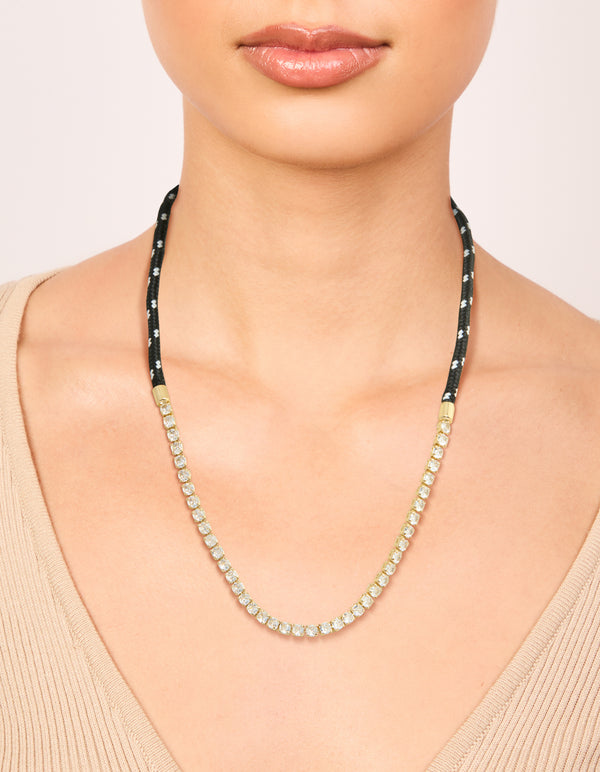 Highlighting a waterproof tennis necklace in gold plated stainless steel with black cord, featuring statement design on neck view