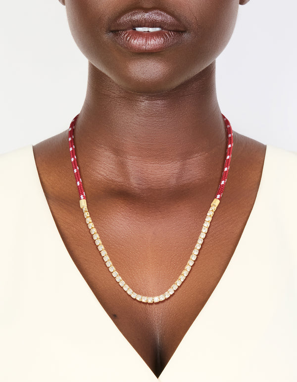 Showcasing a waterproof half tennis and half burgundy cord necklace, crafted from gold plated stainless steel in a statement style on neck view