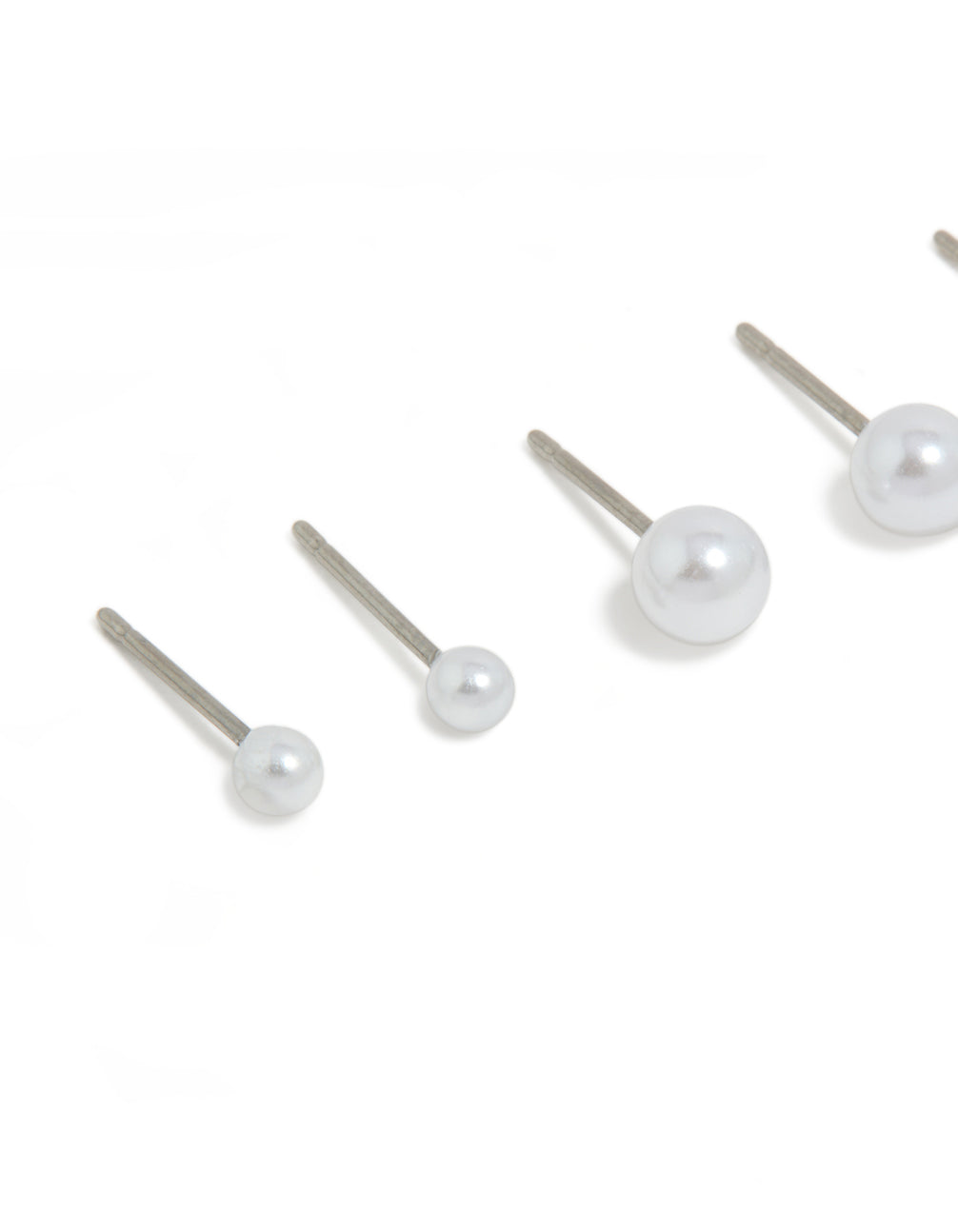Highlighting surgical steel graduating pearl stud earrings in white and silver with 3-pack close up view